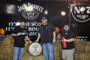 Team KingBBQ carrying a wooden certificate conveying their achievement in the 36th Jack Daniel's World Championship BBQ. 